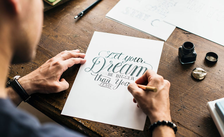 A male figure at a desk creating art.